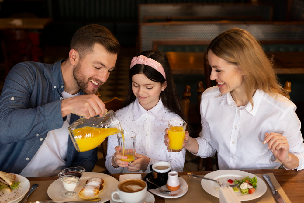 Family Sitting At The Table Having Breakfast