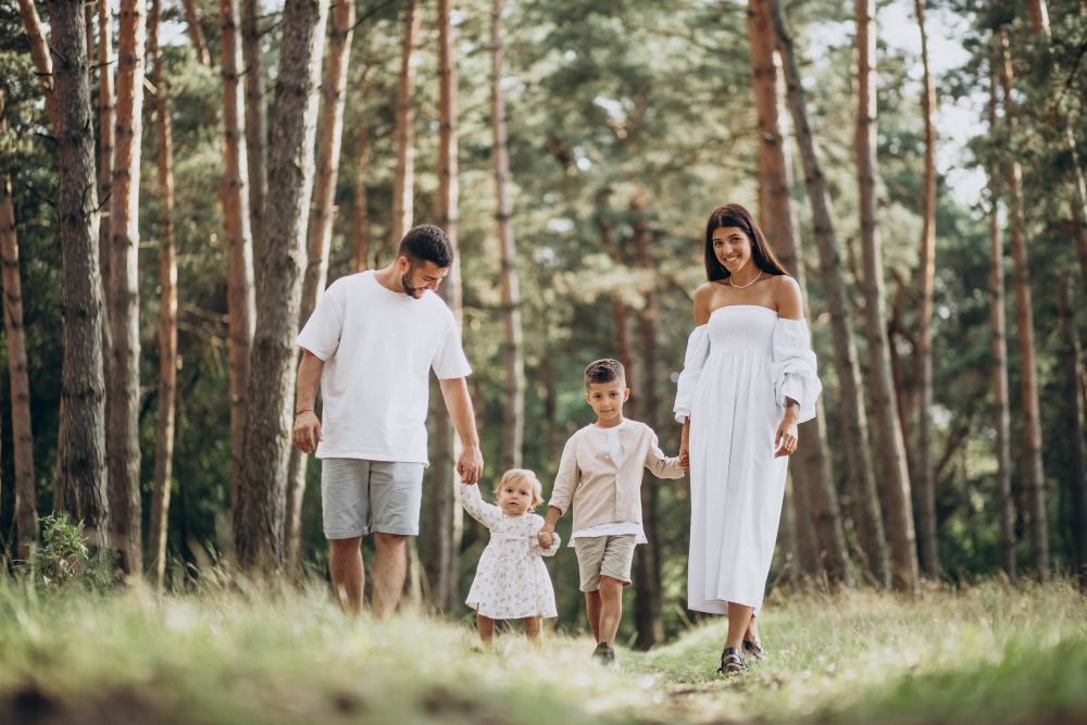 Family With Baby Daughter And Son Holding Hands Walking Through The Park