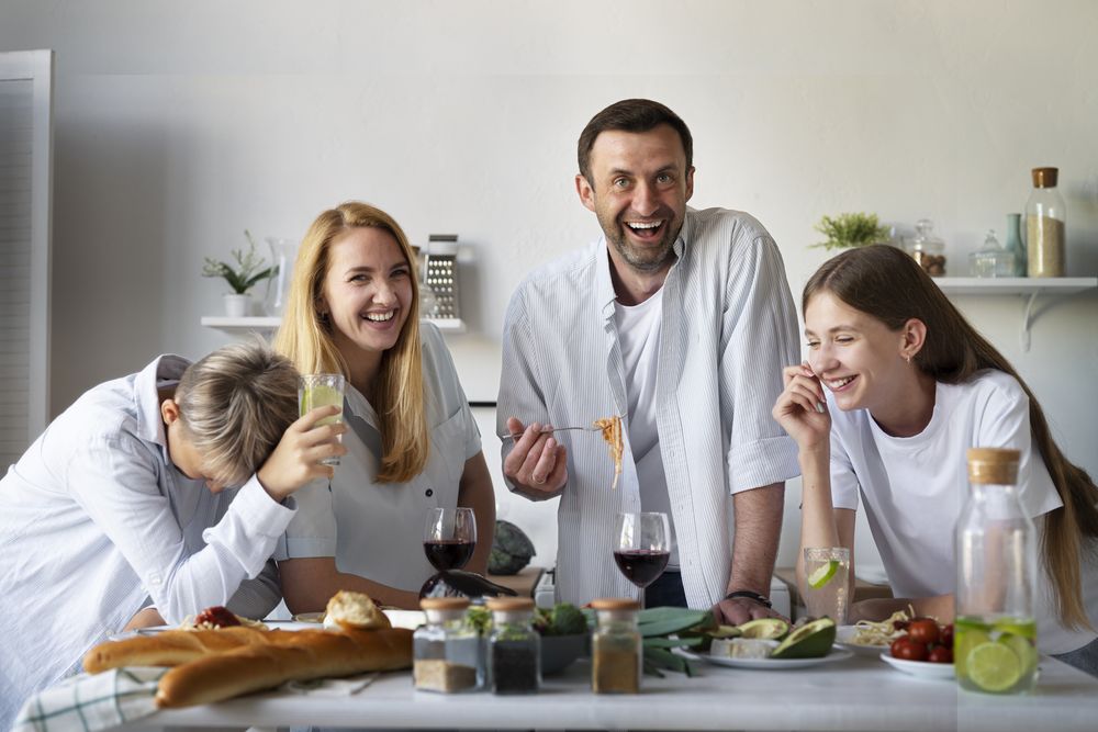 Family Laughing Together While Eating In Kitchen At Home