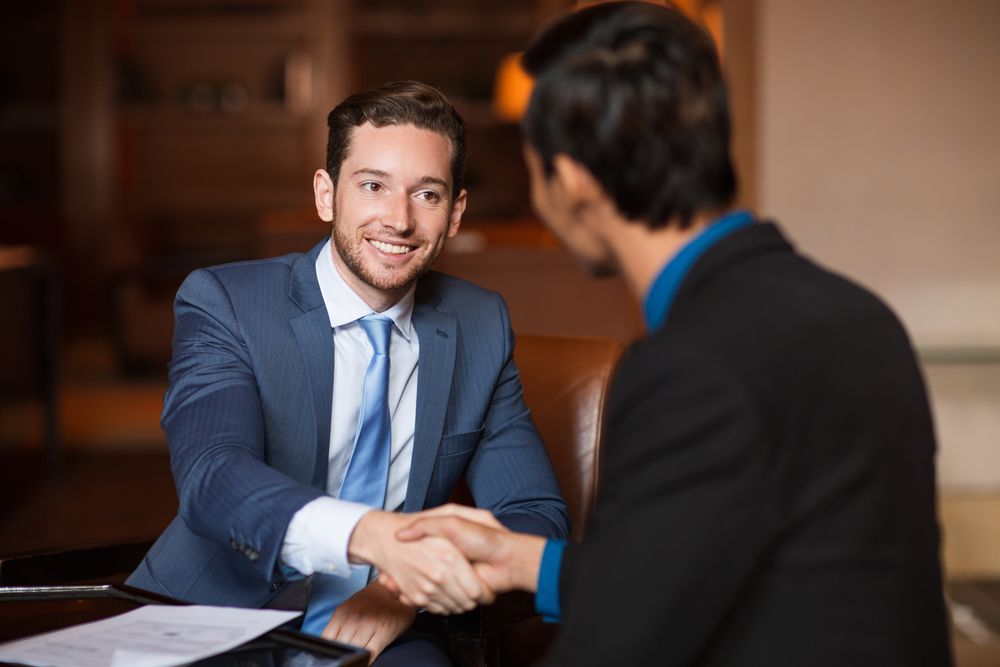 Two Business Partners Shaking Hands In Cafe