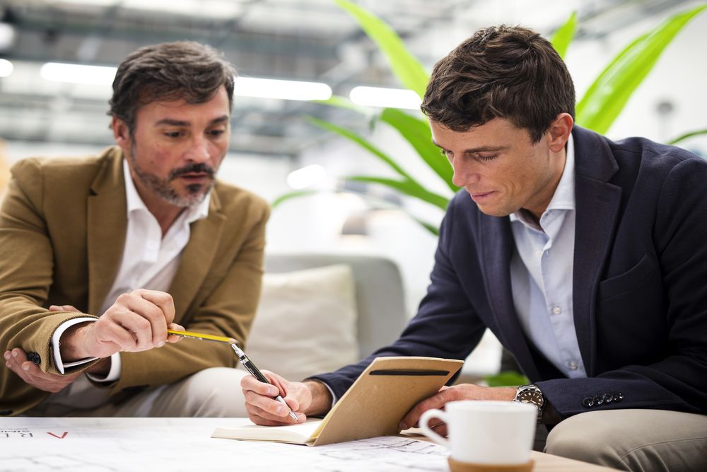 Two Coworkers Meeting In The Office Reviewing Paper Work