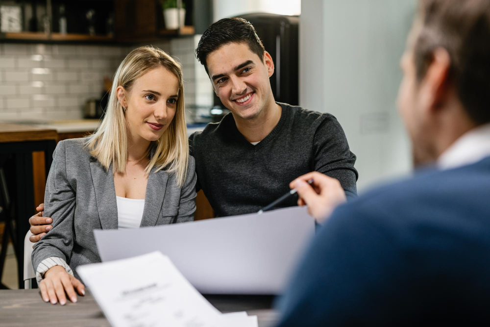 Young Couple Having A Meeting With Insurance Advisor At Home